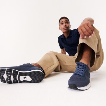 Gabor herrskor | En man sitter på golvet, bär blå sneakers med vit sula – Vår/Sommar 2026 | © Gabor Shoes GmbH, Rosenheim