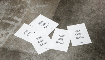 Mehrere weiße Karten mit der Aufschrift „JOIN OUR TEAM“ liegen auf Betonboden. | © Gabor Shoes GmbH, Rosenheim