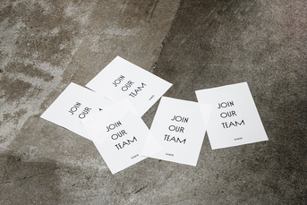 Mehrere weiße Karten mit der Aufschrift „JOIN OUR TEAM“ liegen auf Betonboden. | © Gabor Shoes GmbH, Rosenheim