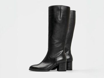 Svarta knähöga läderstövlar från Gabor med blockklack mot vit bakgrund. | © Gabor Shoes GmbH, Tyskland
