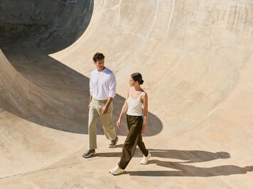 Een man en een vrouw lopen naast elkaar in een skatepark en dragen casual kleding en sneakers. | © Gabor Shoes GmbH, Duitsland