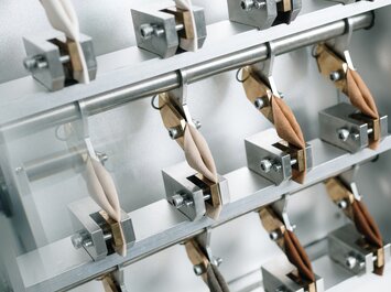 Campioni di pelle di diversi colori sono fissati in una macchina di prova e vengono testati meccanicamente. | © Gabor Shoes GmbH, Germania