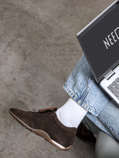 Person mit braunen Sneakern arbeitet am Laptop, auf dem „NEED HELP?“ zu lesen ist. | © Gabor Shoes GmbH, Rosenheim