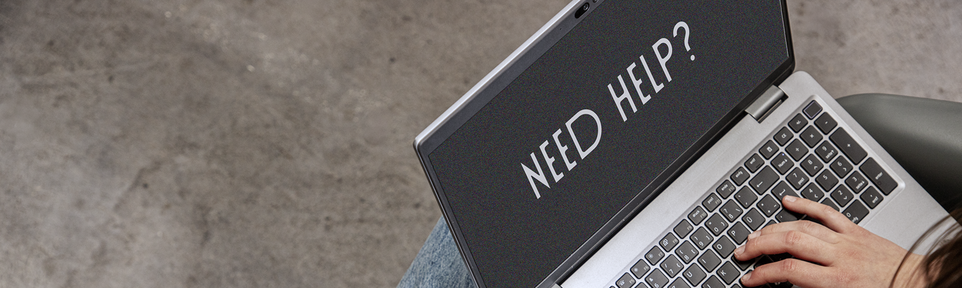 Person mit braunen Sneakern arbeitet am Laptop, auf dem „NEED HELP?“ zu lesen ist. | © Gabor Shoes GmbH, Rosenheim