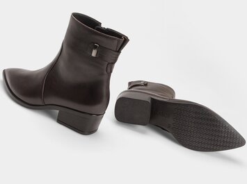 Mörkröd ankelboot med ett sidospänne bredvid sin profilerade yttersula mot en ljus bakgrund. | © Gabor Shoes GmbH, Tyskland