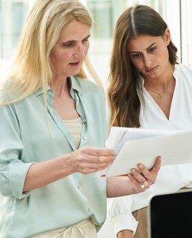 Zwei Personen schauen gemeinsam auf Unterlagen. | © Gabor Shoes GmbH, Rosenheim