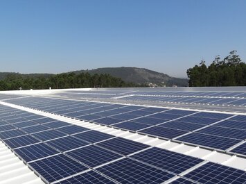 Solarmodule auf einem Dach vor Bäumen und Hügeln. | © Gabor Shoes GmbH, Rosenheim
