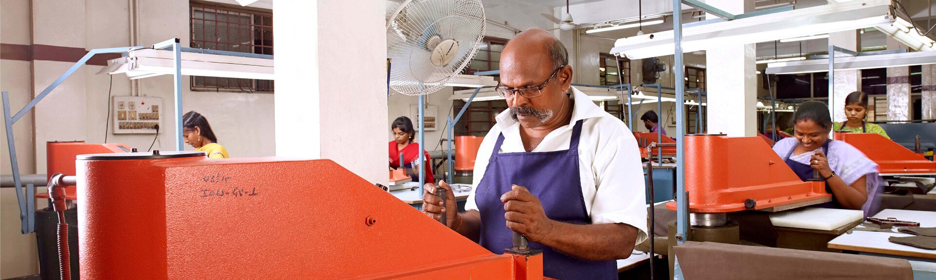 Personen arbeiten an Maschinen in einer Fabrikhalle. | © Gabor Shoes GmbH, Rosenheim
