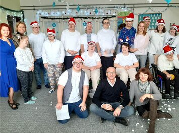 Gruppenfoto bei einer Weihnachtsfeier, viele tragen Nikolausmützen. | © Gabor Shoes GmbH, Rosenheim